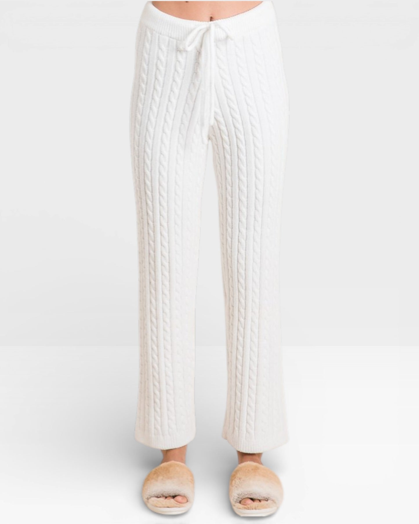 White cable knit pants worn by a person on a white background