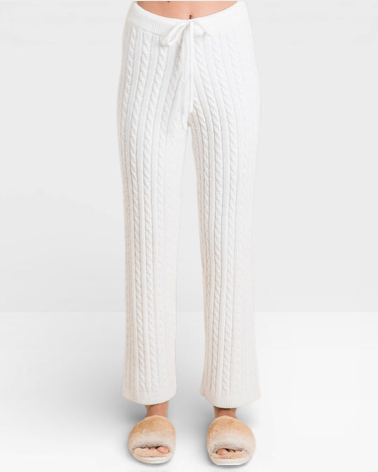 White cable knit pants worn by a person on a white background