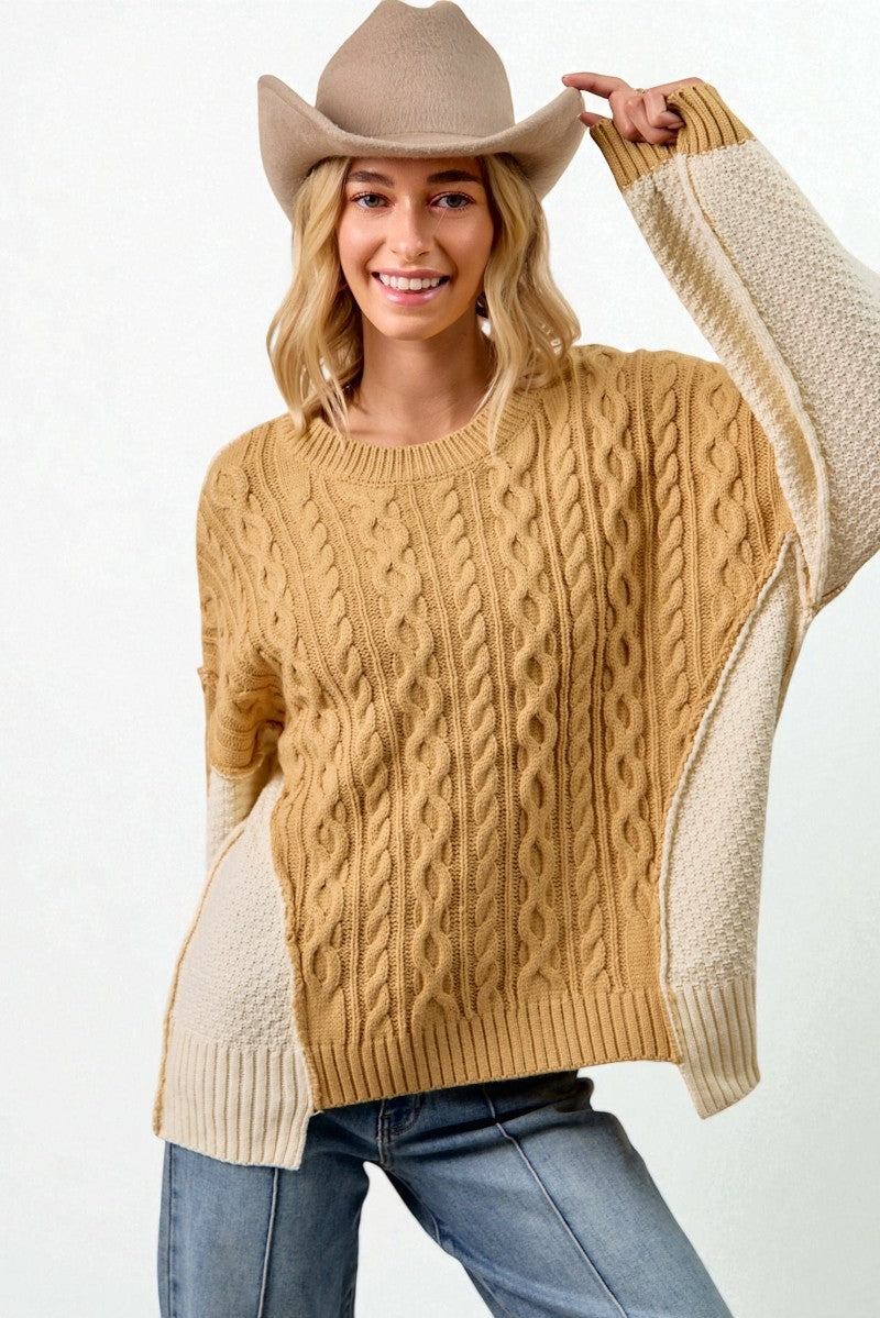 Woman wearing a beige and brown sweater with a cowboy hat on a white background
