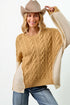 Woman wearing a beige and brown sweater with a cowboy hat on a white background