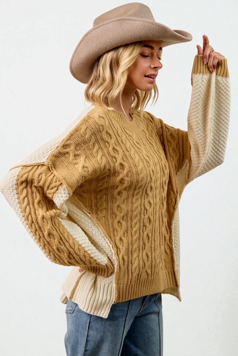 Woman wearing a mustard yellow sweater with white cuffs and hem, blue jeans, and a beige cowboy hat on a white background.