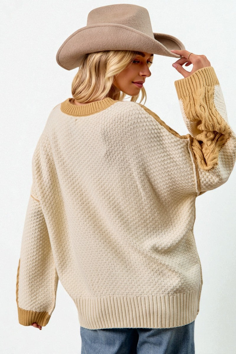 Woman wearing a beige sweater and cowboy hat against a white background