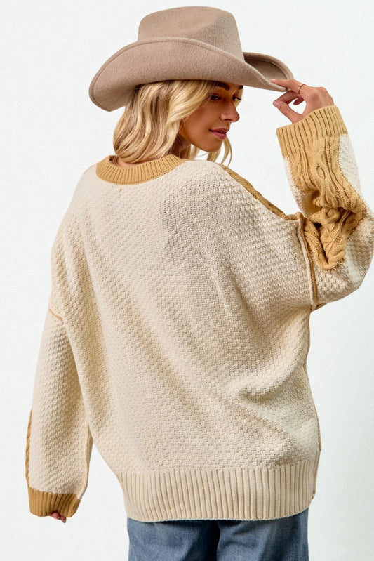 Woman wearing a beige sweater and cowboy hat against a white background