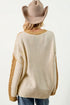 Person wearing a cream sweater with brown accents and a beige cowboy hat on a white background