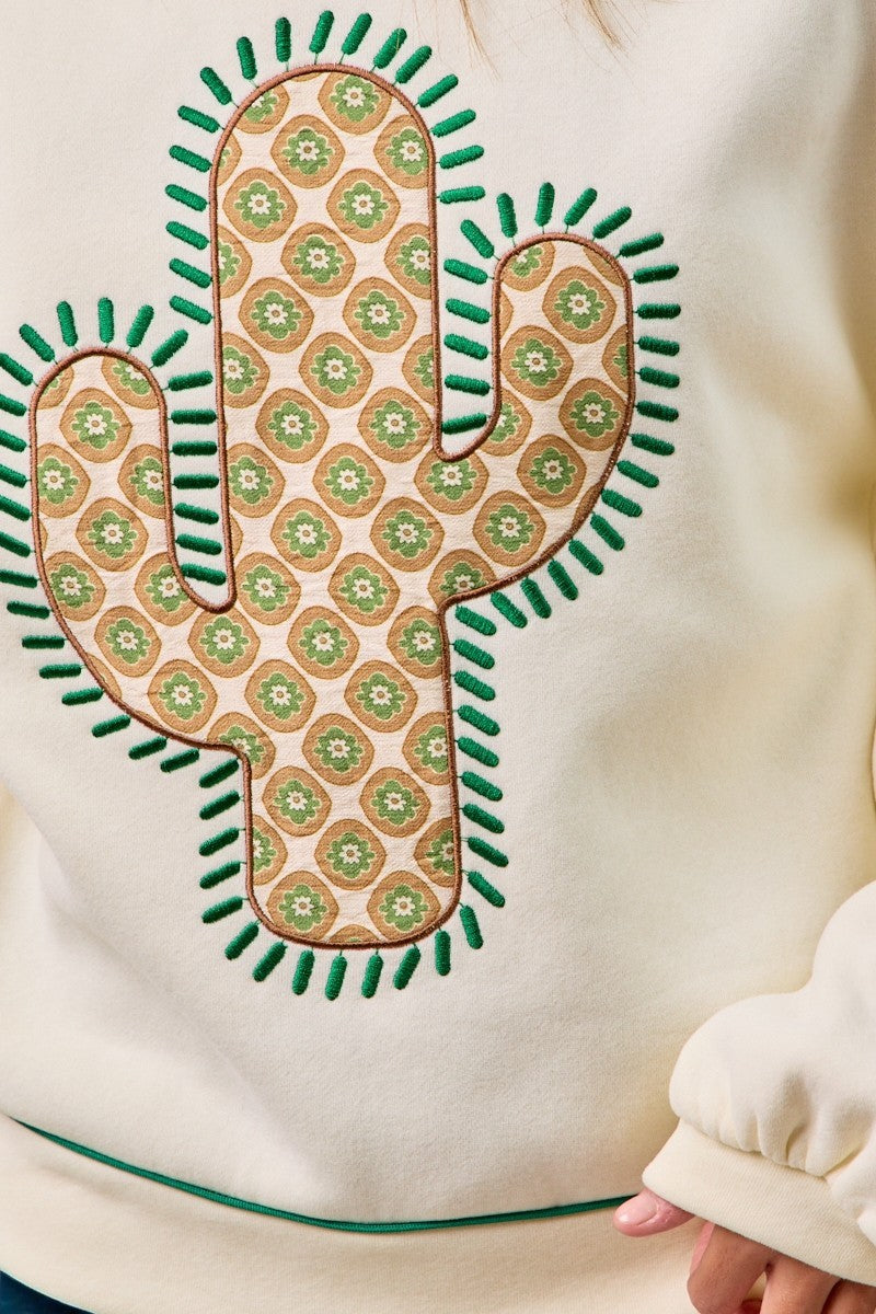 Sweatshirt with a cactus-shaped design featuring a geometric pattern on a beige background.