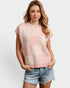 Woman wearing a pink and beige checkered sleeveless top with denim shorts on a white background