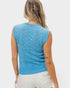 Woman wearing a blue sleeveless knitted top on a white background