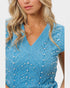 Blue knitted top with pearl embellishments on a white background