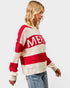 Woman wearing a red and white striped sweater with 'MERRY' text on a light gray background