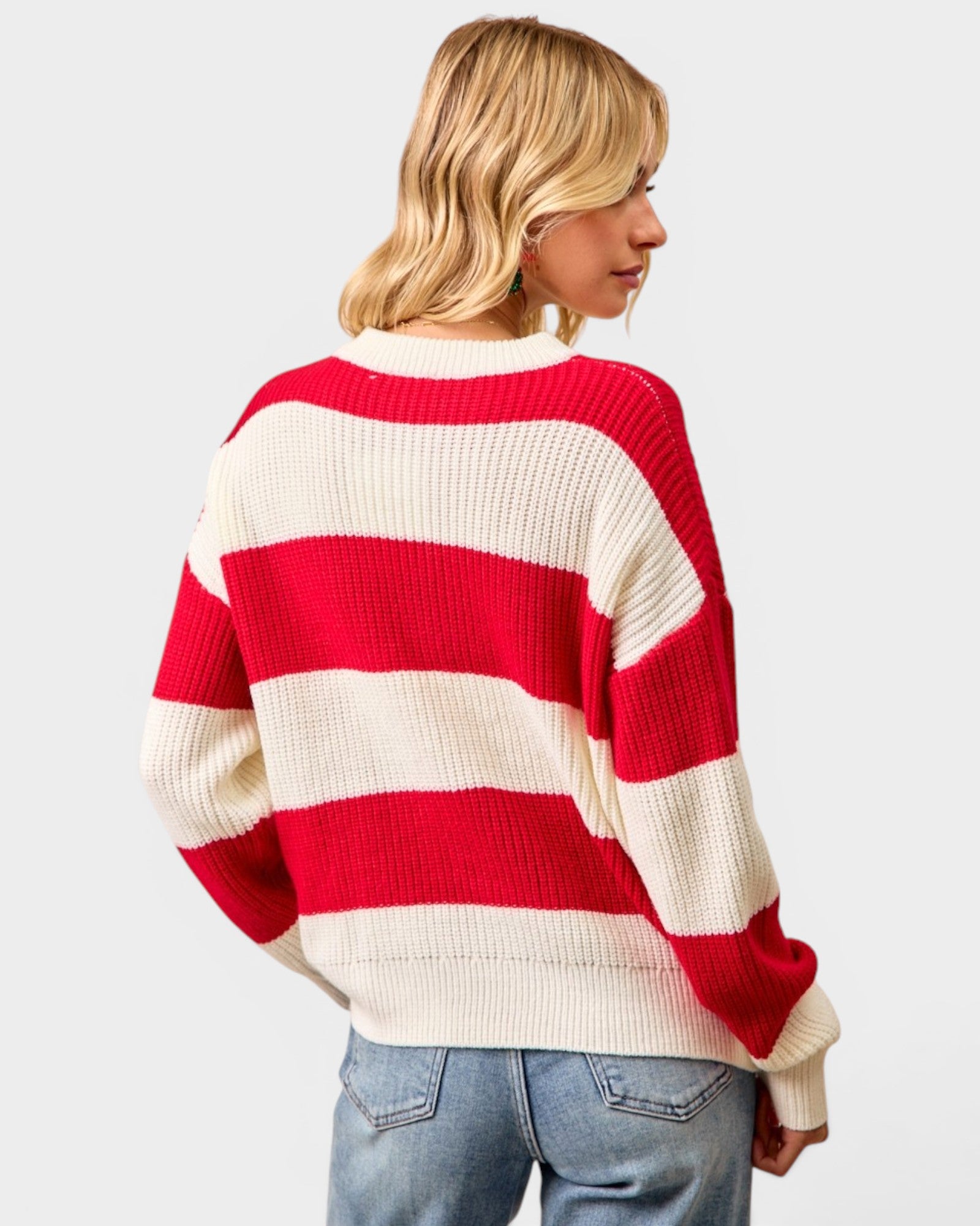 Person wearing a red and white striped sweater on a plain background