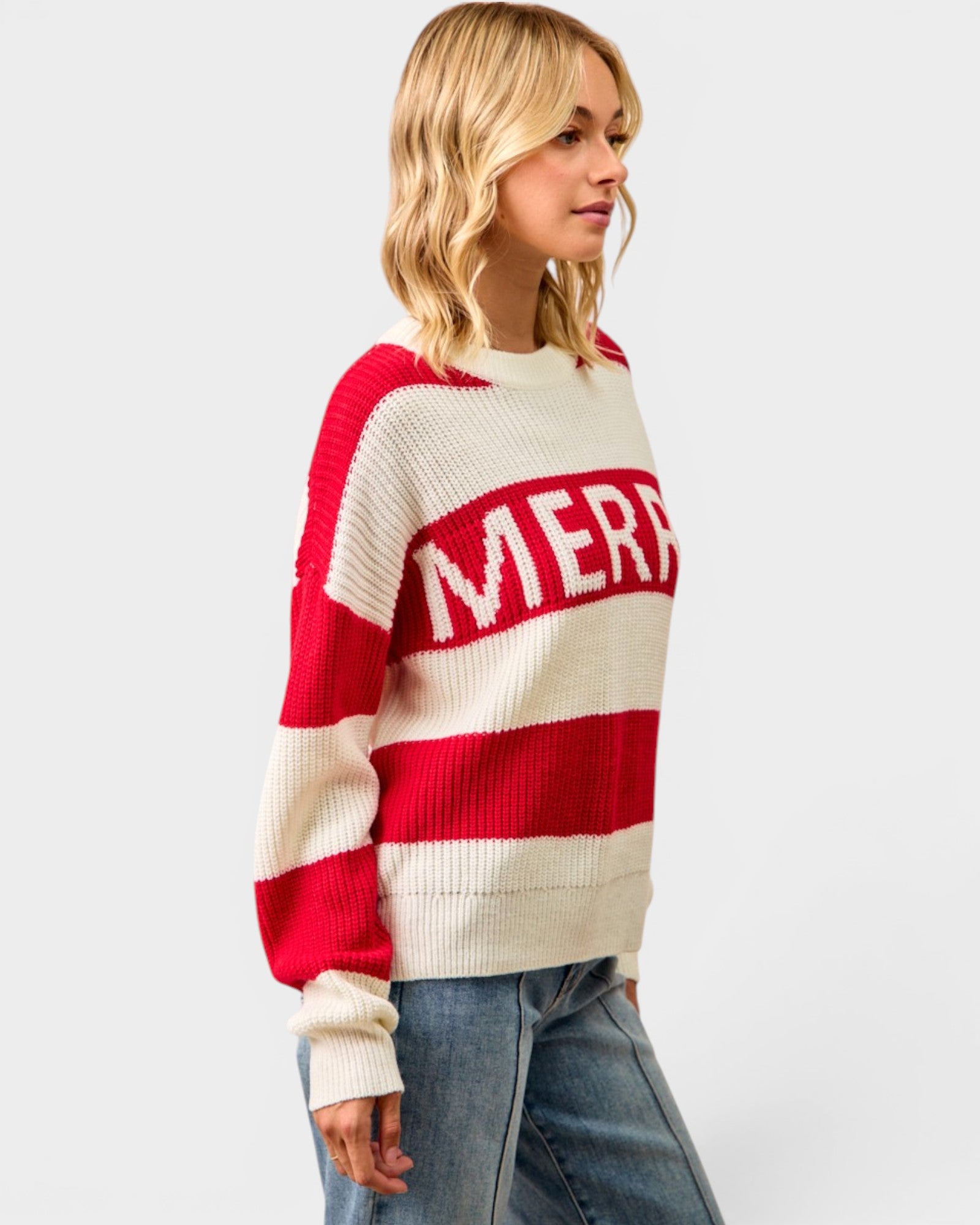 Woman wearing a red and white sweater with 'MERRY' text on a plain background
