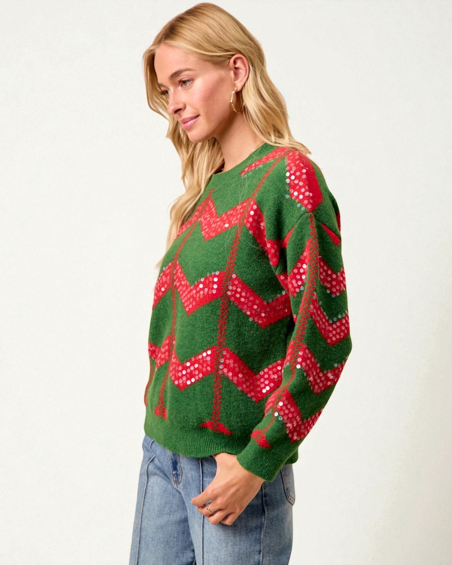 Woman wearing a green sweater with red patterns on a white background