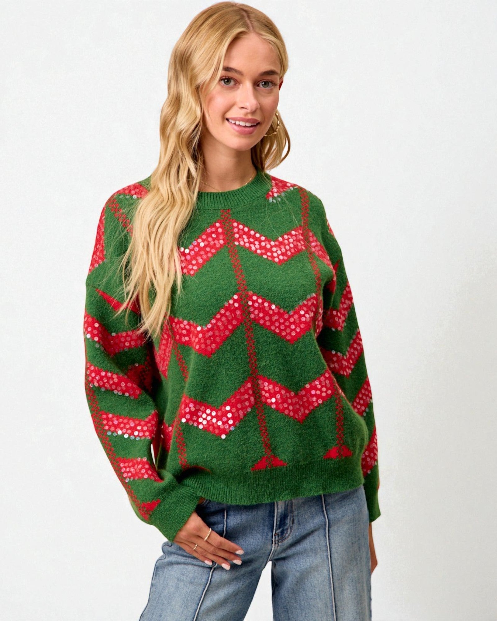 Woman wearing a green sweater with red patterns on a white background