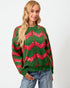 Woman wearing a green sweater with red patterns on a white background
