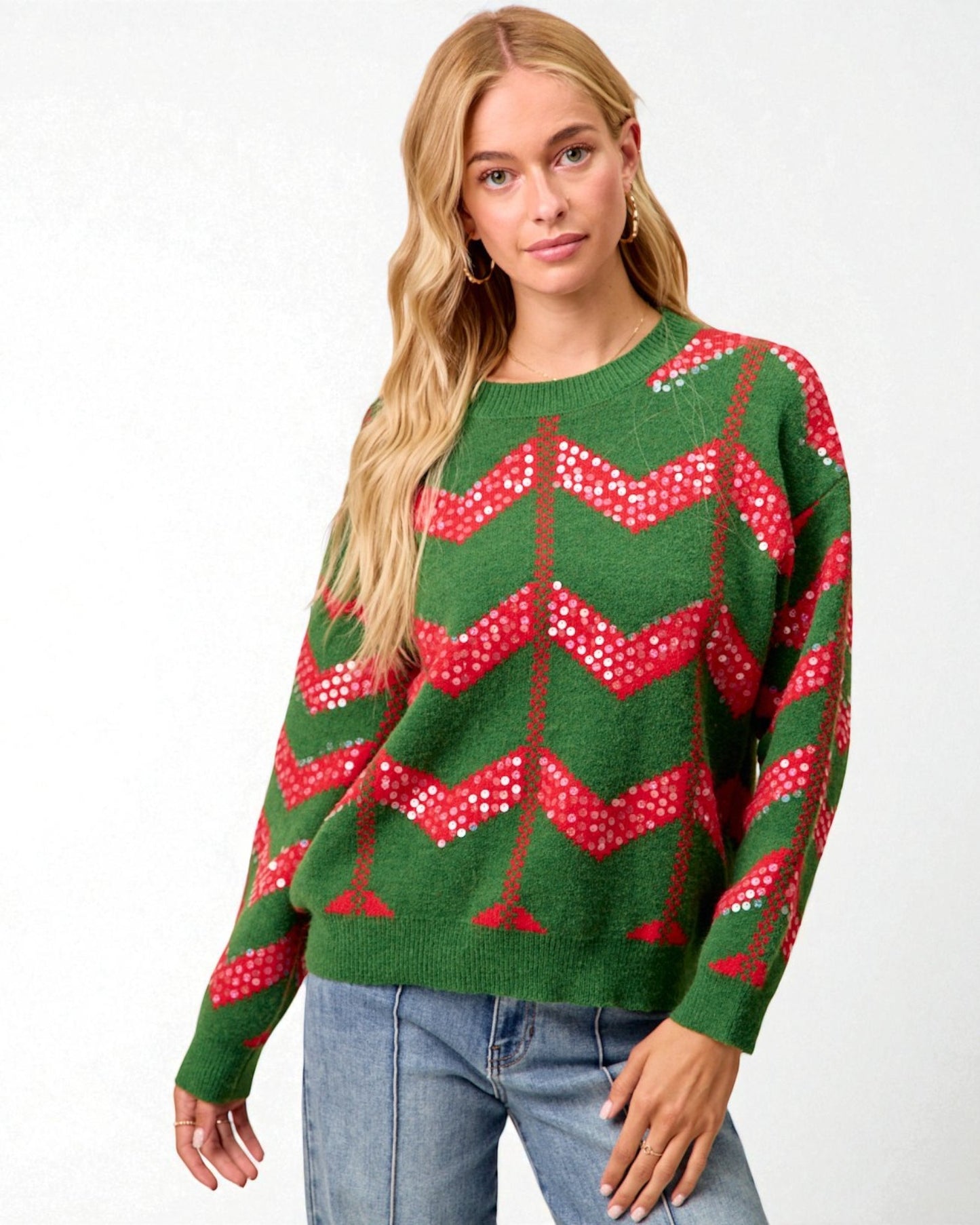 Woman wearing a green sweater with red and white pattern on a white background