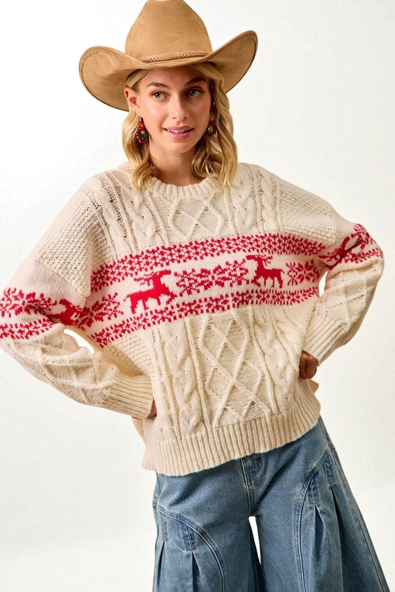 Woman wearing a cream sweater with red deer pattern and a cowboy hat on a white background