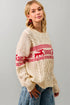 Woman wearing a cream sweater with red and white pattern against a gray background