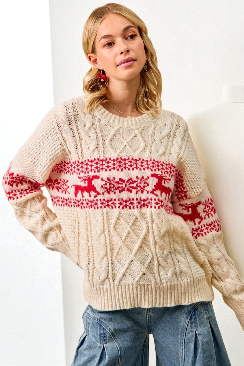 Woman wearing a cream sweater with red reindeer pattern against a white background