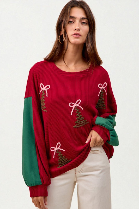 Woman wearing a red sweater with Christmas tree and bow designs on a white background