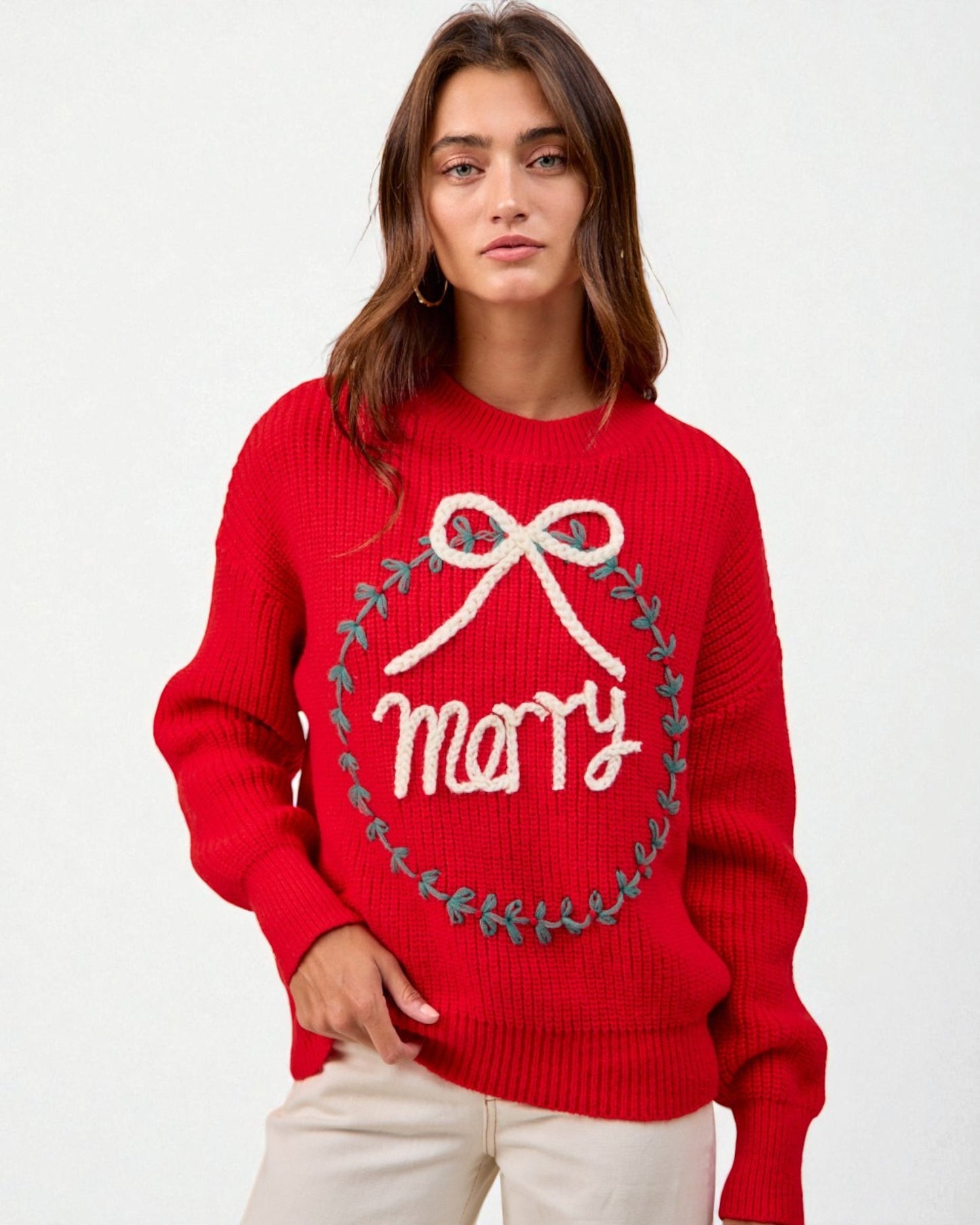 Person wearing a red sweater with 'merry' and a bow design on a white background