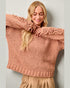 Woman wearing a pink sweater with lace details against a plain background