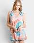 Woman wearing a tie-dye dress with ruffled sleeves on a plain background