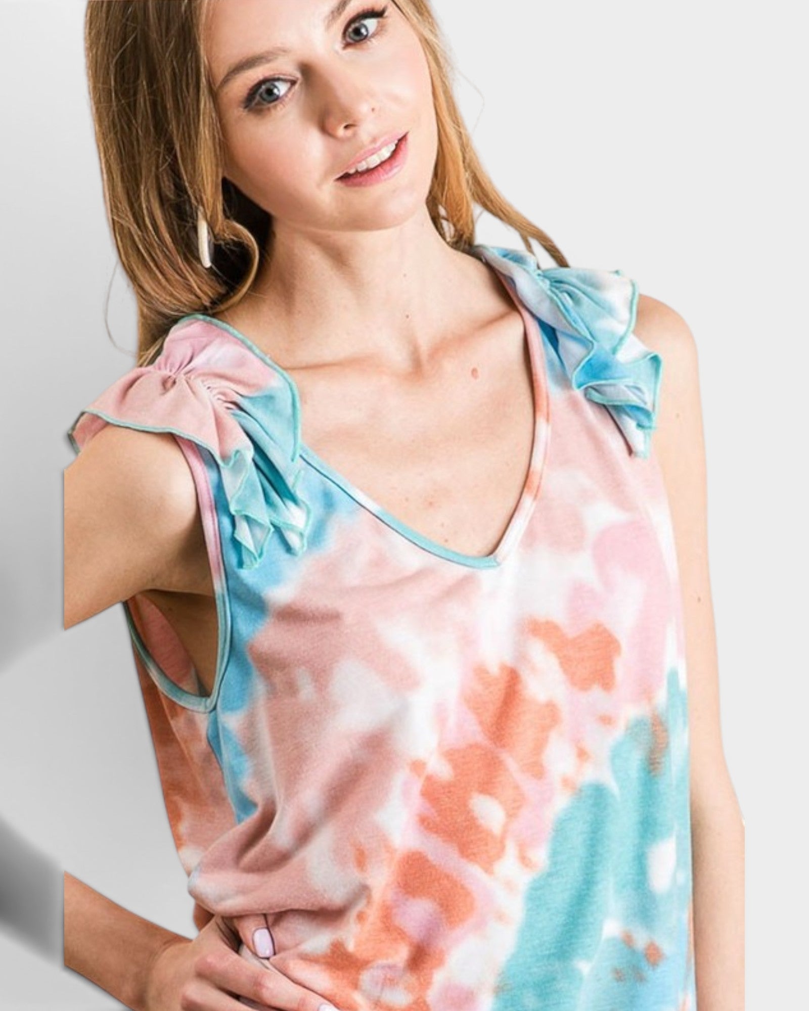 Woman wearing a sleeveless top with floral design on a plain background