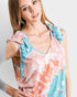 Woman wearing a sleeveless top with floral design on a plain background