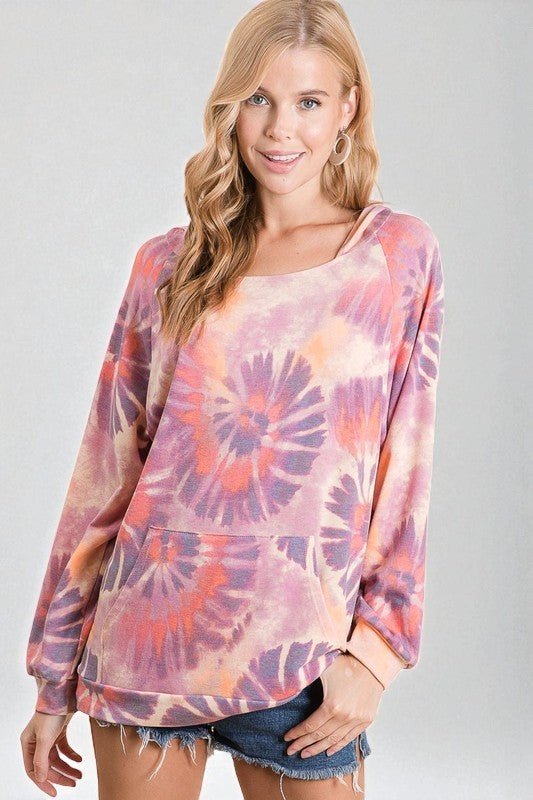 Woman wearing a tie-dye long-sleeve top on a plain background