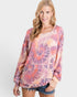 Woman wearing a tie-dye long-sleeve top on a white background