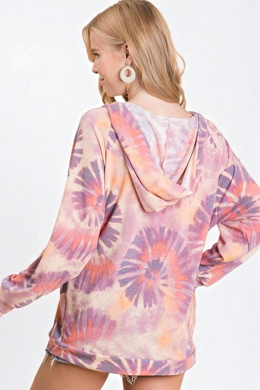 Woman wearing a tie-dye hoodie with a white background