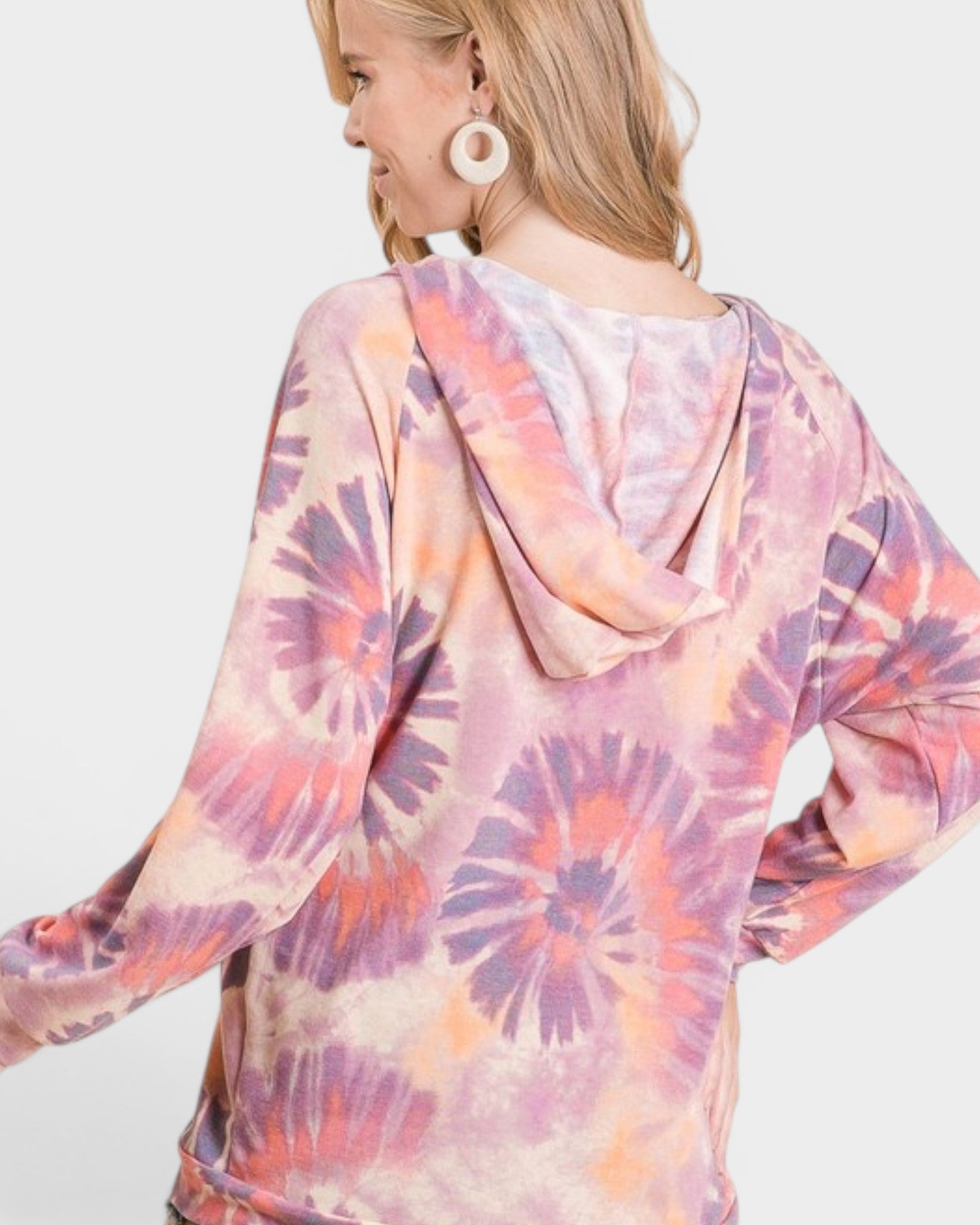 Woman wearing a tie-dye hoodie with a white background
