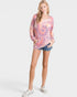Woman wearing a tie-dye shirt and denim shorts on a white background