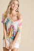 Woman wearing a colorful off-shoulder top against a beige background
