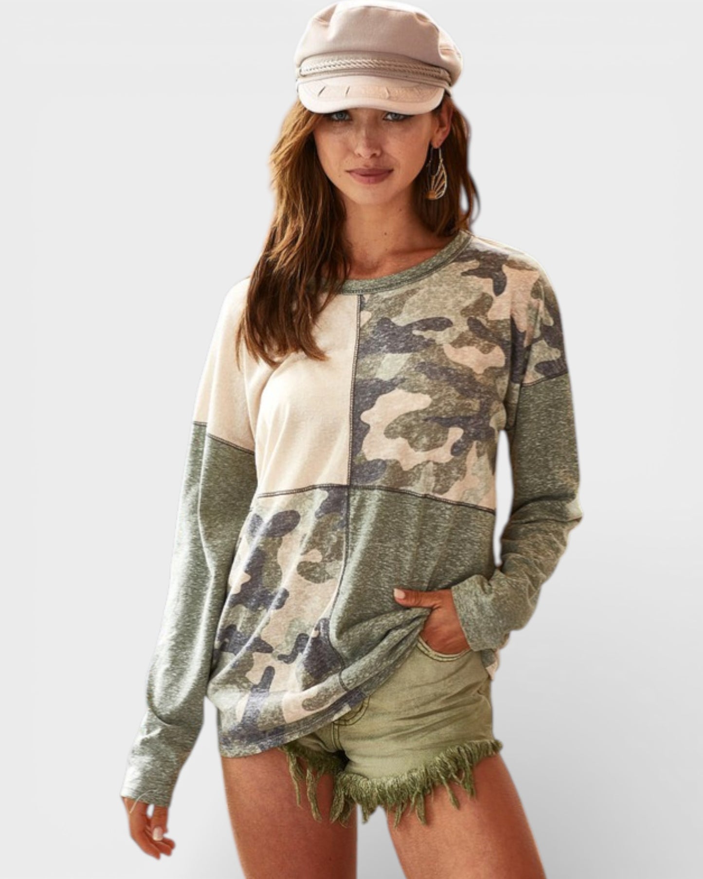 Woman wearing a camouflage sweater with a plain background