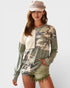 Woman wearing a camouflage sweater with a plain background
