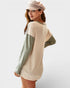 Woman wearing a beige sweater with green sleeves on a white background