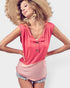 Woman wearing a pink sleeveless top and straw hat on a white background