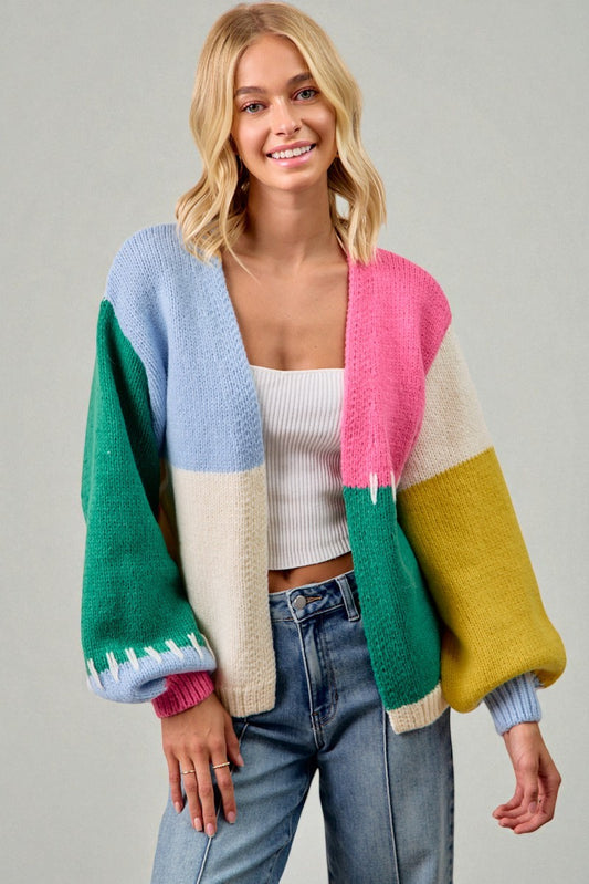 Woman wearing a colorful cardigan with a plain background