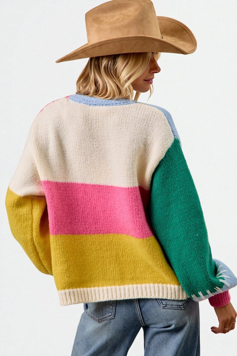 Person wearing a colorful sweater with a neutral background