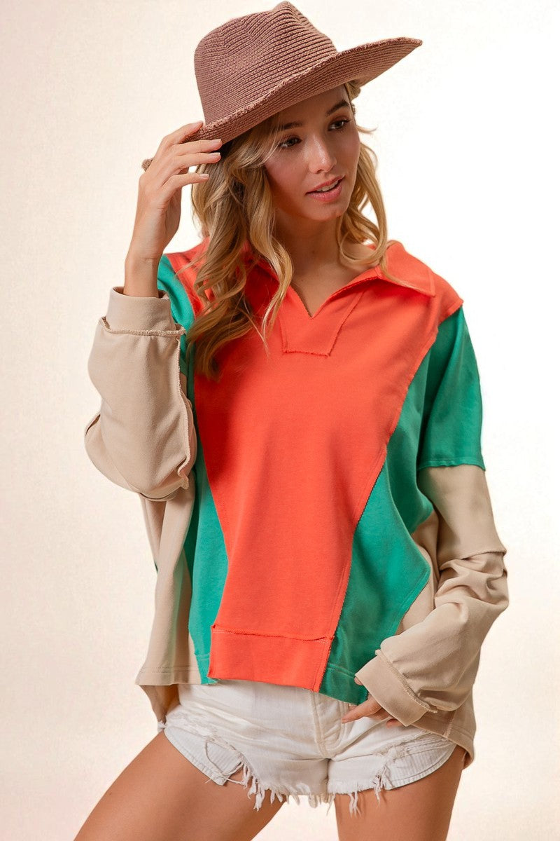 Woman wearing a colorful jacket with a beige hat on a light background