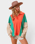 Woman wearing a colorful hooded sweater and hat on a white background