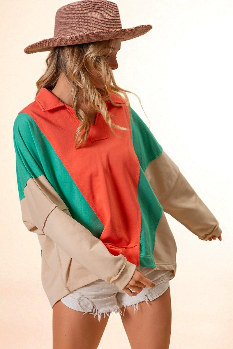 Woman wearing a colorful sweater with a wide-brimmed hat on a beige background