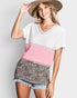 Woman wearing a color-blocked top with pink and leopard print elements on a plain background