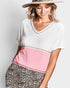 Woman wearing a white and pink top with leopard print pants on a plain background