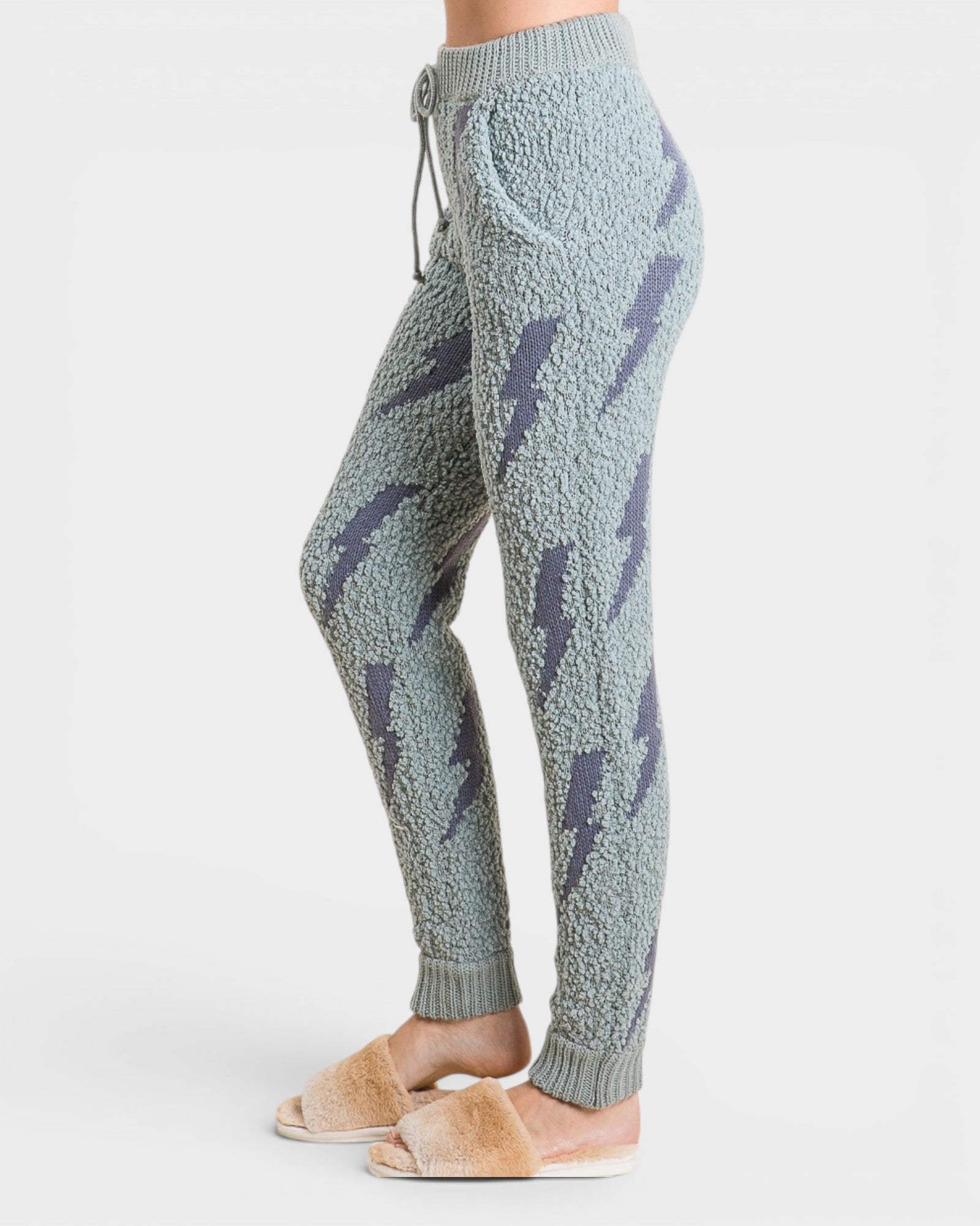 Light blue knit jogger pants with dark blue abstract patterns on a white background
