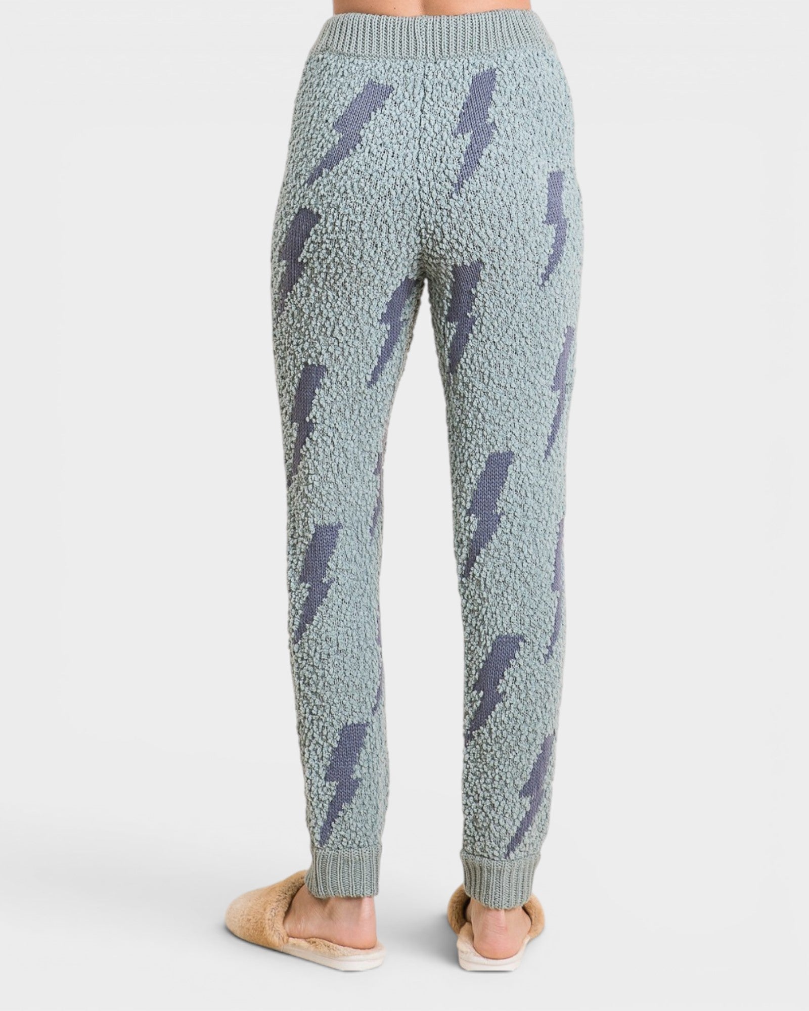 Light blue knitted pants with lightning bolt pattern on a white background