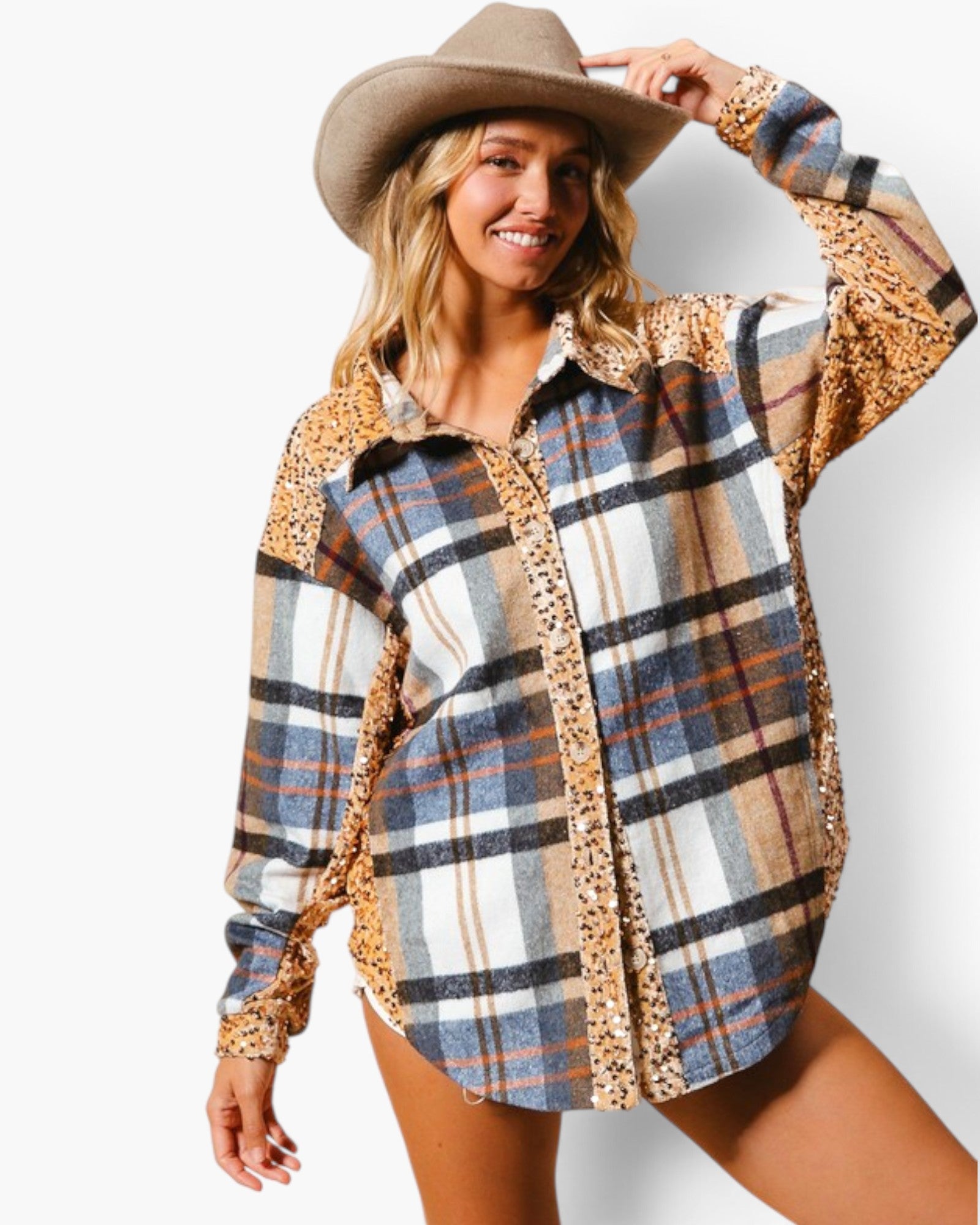 A woman wearing a long-sleeve plaid button-up shirt with leopard-print shoulder and side panels, paired with a brown cowboy hat, against a plain white studio background.