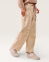 Person wearing beige striped pants and matching shoes on a white background