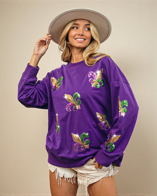 Woman wearing a purple sweatshirt with colorful designs on a beige background